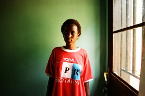 Florence, 18 ans, vit à Kamonyi à une 1H30 de la capitale. Lorsque les orphelins ont grandi, il a fallu trouver une solution pour les loger. Ils n’avaient aucun bien, ceux-ci ayant été détruits ou pillés durant les massacres. L’Etat et certaines ONG ont alors construit des quartiers pour les orphelins et les veuves, les umugudu. Florence vit dans un de ses « villages ». Elle partage une maison avec trois autres adolescents. Elle porte un T-Shirt du FPR, le Front Patriotique Rwandais, qui arrêta le génocide par son intervention depuis l'Ouganda. C'est aujourd'hui le parti au pouvoir.
